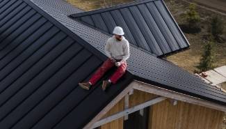 long shot man with helmet sitting roof